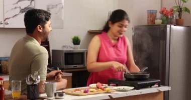 Karı koca konuşuyor ve yemek hazırlıyorlar.