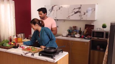 Adam kadına mutfakta nasıl doğranacağını öğretiyor.