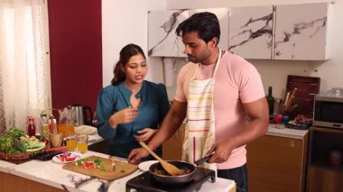 Hintli çift mutfak tezgahında ailelerine yemek hazırlıyor.