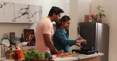 Mutfakta birlikte yemek pişiren çift.