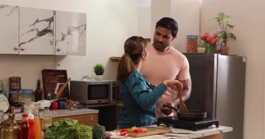 Mutfakta birlikte yemek pişiren çift.