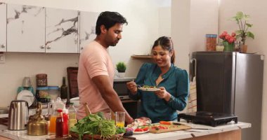 Kadın kocasını elleriyle besliyor.