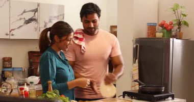 Karı koca kıkırdıyor ve chapattis yapıyor.