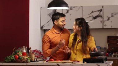 Lezzetli, gurme ve sağlıklı yemek kokusu alan çift mutfakta konuşuyor. Romantizm, kucaklaşma ve kadın ve erkek yemek hazırlıyor, eğleniyor ve birlikte vakit geçiriyorlar.