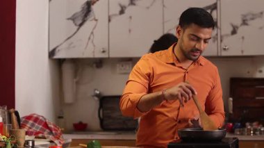 Tencerede Yemek Pişiren Çekici Genç Bir Çift. Mutfakta dans edip eğleniyorlar..