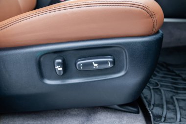 Elektrikli koltuk ayarlarıyla yakın plan iç görünüş, lüks düğmeler çok pahalı yeni kahverengi araba standları, araç tamir atölyesinde temizlik ve onarım yaptıktan sonra. Otomobil hizmet endüstrisi