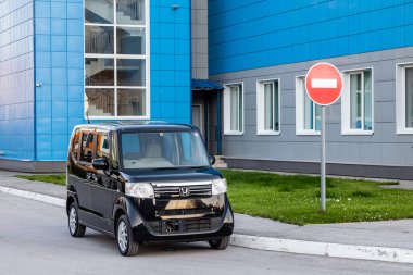 Pavlodar, Kazakistan - 08.03.2022: Honda N-Box kei araba dış görünümü kentsel stil arka planında trafik işaretinin yanındaki büyük şehir.