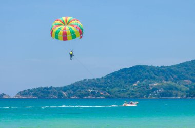 Phuket, Tayland 'daki güzel Patong plajında renkli paraşüt beyaz kum, turkuaz su ve palmiye ağaçları