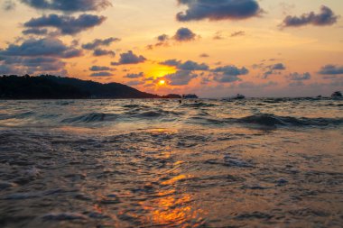 Okyanustaki dalgaların manzarası ve altın saatinde bronz güneşin Tayland 'da gün batımında Phuket adasında, patong plajında görüldüğü inanılmaz bir manzara.