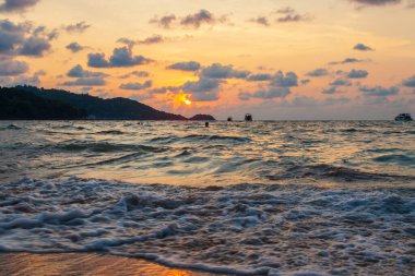 Okyanustaki dalgaların manzarası ve altın saatinde bronz güneşin Tayland 'da gün batımında Phuket adasında, patong plajında görüldüğü inanılmaz bir manzara.