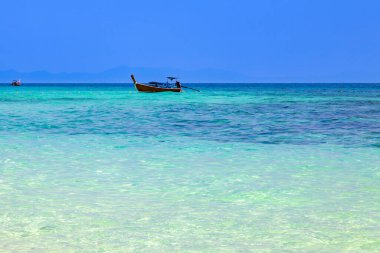Andaman Denizi 'nde turistleri balık tutmak ve taşımak için kullanılan eski geleneksel Tayland motorlu teknesi mavi gökyüzünün altında turkuaz sularda. Pofet 'te seyahat ve tatil.