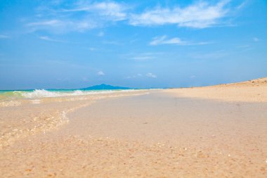 Tayland 'da Bambu adası sahilinde açık turkuaz su ve sıcak bir günde mavi gökyüzü ile temiz sarı kum. Tatildeyken Tayland 'a seyahat ve tatil.