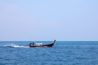 Andaman Denizi 'nde turistleri balık tutmak ve taşımak için kullanılan eski geleneksel Tayland motorlu teknesi mavi gökyüzünün altında turkuaz sularda. Pofet 'te seyahat ve tatil.