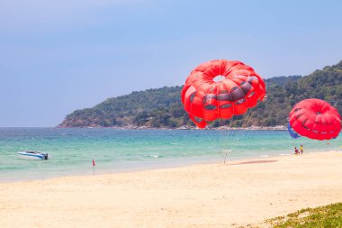 Phuket Adası 'ndaki Tayland' daki güzel parlak karon plajı. Denizde turkuaz su, şemsiyeli beyaz kum ve mavi gökyüzü. Asya 'nın sıcak ülkelerinde popüler bir turistik yer..