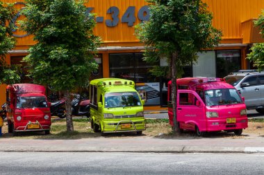 Tayland, Patong - 03.27.23: Tayland 'da Phuket adasında Tuk Tuk adlı turistler için taksiye dönüştürülmüş küçük Japon kamyonları. Şehrin sokaklarında çok renkli arabalar var..