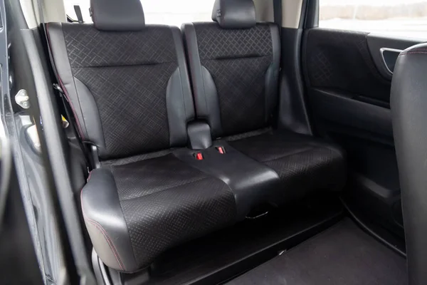 Close-up on rear seats with velours fabric upholstery in the interior of an modern japanese car in gray after dry cleaning. Auto service industry.