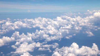 Mavi gökyüzünde uçarken beyaz kabarık bulutlar