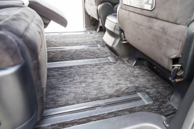 Clean car floor mats of black carpet with gas pedals and brakes in the workshop for the detailing vehicle after dry cleaning clipart