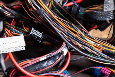 Arabanın elektrik kablolarında konnektörleri olan farklı renkte mat kablolardan oluşan bir kablo. Tedarikçinin çalışmasında internet hattı.