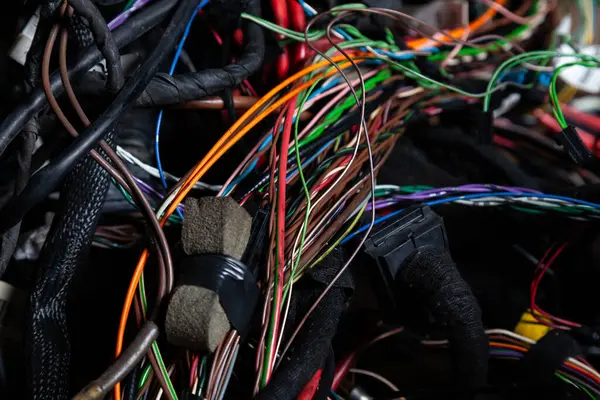 Arabanın elektrik kablolarında konnektörleri olan farklı renkte mat kablolardan oluşan bir kablo. Tedarikçinin çalışmasında internet hattı.