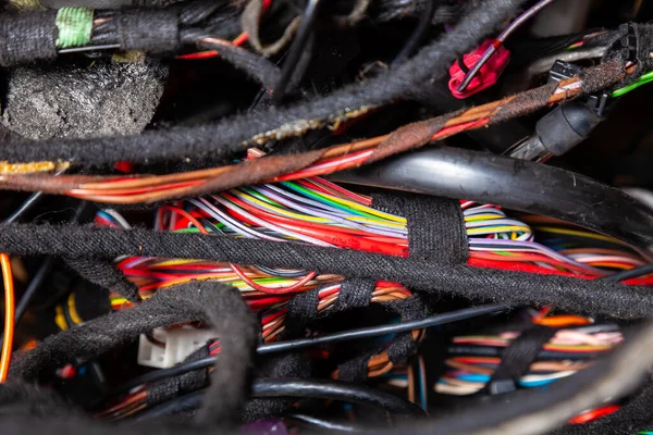 Arabanın elektrik kablolarında konnektörleri olan farklı renkte mat kablolardan oluşan bir kablo. Tedarikçinin çalışmasında internet hattı.