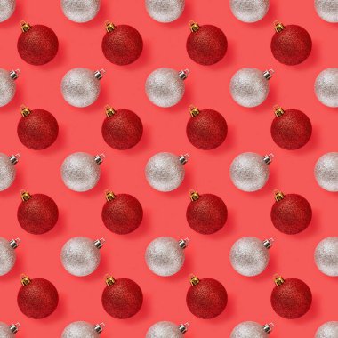 Kırmızı ve gümüş noel toplarının kusursuz deseni kırmızı arka planda. Noel arifesi ve yeni yıl deseni tebrik kartı maketi için. Kış tatili tasarım elemanı. Makro. Üst görünüm.