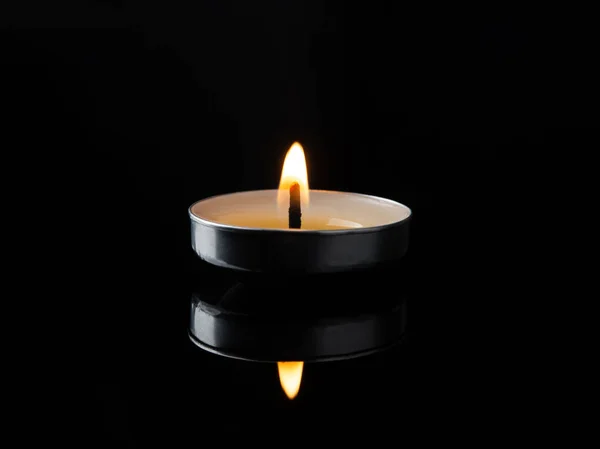 Hořící Čajová Svíčka Tmě Lit Svíčka Odráží Černém Lesklém Povrchu — Stock fotografie