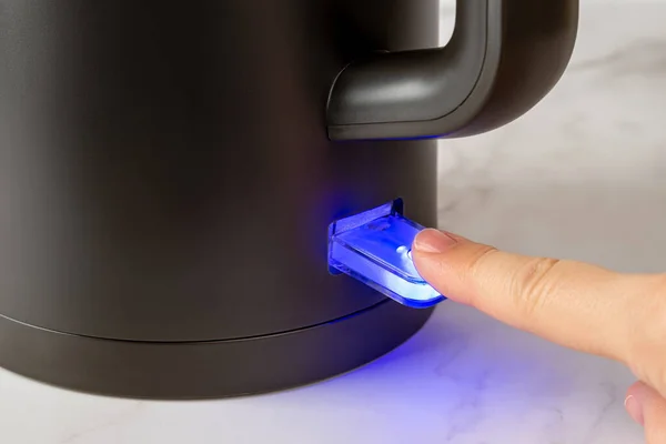 손가락 주전자를 끓이는 스위치를 스위치는 전원을 푸른색으로 집니다 커피를 끓이기 — 스톡 사진