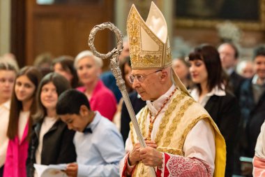 GENOA, ITALY - APRIL 22 2023: Archbishop Angelo Bagnasco during the Mass in the Communion Rite in Assunta Church in Sestri Ponente clipart
