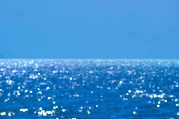 Bulanık parlak deniz arka planı ve açık gökyüzü gün ışığında, denizde bokeh