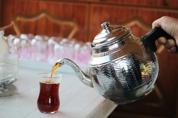 Gümüş kaplama çaydanlıktan taze çay yaprakları dökülüyor.