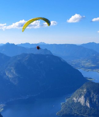 Avusturya 'nın Salzburg bölgesindeki dağlarda yakın bir rehberle paraşütle atlama.
