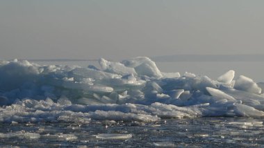 Winter river, ice ridges, forest.