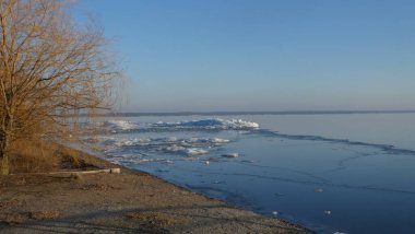 Winter river, ice ridges, forest.