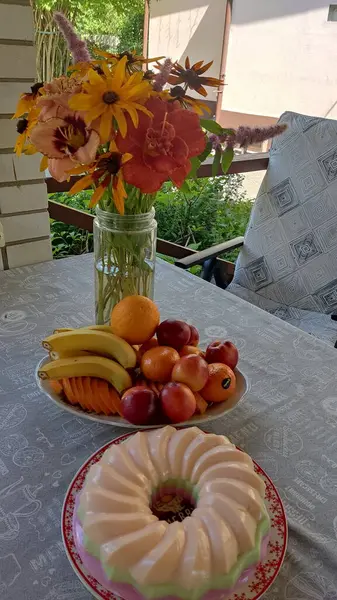 Bir buket çiçek, taze meyve ve ev yapımı kek.