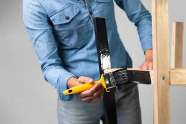 Hobi olarak çocuklar için bir merdiven restore etmeye hazırlanan genç kadınlar. Örtülü bir masada. Fırçayla boyama