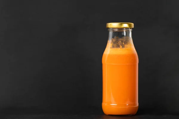 Frisch Gepresster Karottensaft Einer Glasflasche Mit Goldenem Verschluss Auf Schwarzem — Stockfoto
