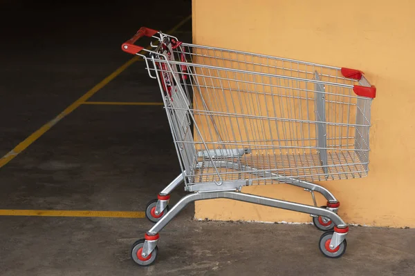 Abandoned shopping cart left in a mall parking lot, signifying neglect and disorder in the area.