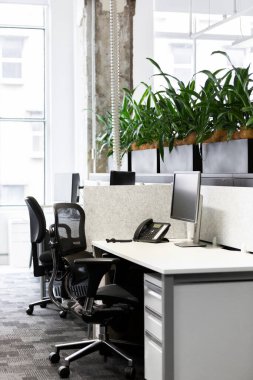 Çağdaş bir ofis içinde düzenli bir masa, çalışma gününün başlamasını bekliyor.