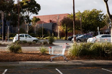 Boş bir alışveriş arabası açık bir otoparkta bırakılmış. Kamu alanındaki kullanılmış perakende malzemelerinin tanıdık bir görüntüsü..