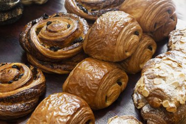 Çikolatalı pastaların, bademli kruvasanların ve Danimarka üzümlü kurabiyelerin yakın plan görüntüsü..