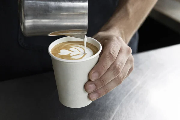 Pouring milk and crafting a fresh latte for a delightful coffee experience.