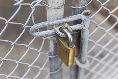 Paslı asma kilit metal bir çite bağlı..