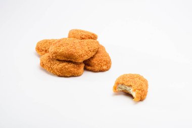 Lezzetli kızarmış tavuk nugget yığını ve kenarından bir ısırık.