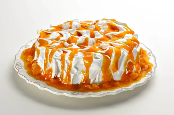Delicious homemade cake with marshmallow topping and peach syrup, ready to eat on a celebration or party. On a white background.