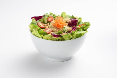 Sağlıklı pişmiş kinoa, rendelenmiş havuç ve vişneli domates salatası, beyaz kasede, izole edilmiş.