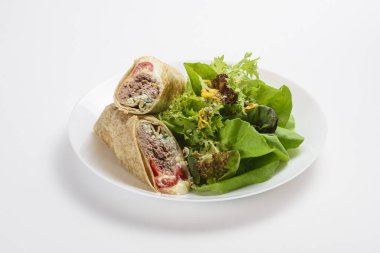 Lezzetli ton balığı ve peynirli dürüm, salata bir yana, soyutlanmış.