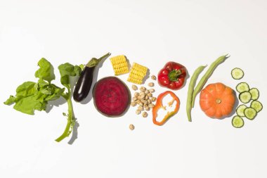 Sağlıklı sebzelerden yapılmış yaratıcı bir düzen. Düz bir zemin, beyaz zemin üzerinde güçlü bir gölge ile üst görünüm kullanılmaya hazır.