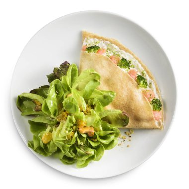 Mayonezli krep, somon ve brokoli, yanında salata. Beyaz bir tabakta, beyaz bir arka planda.