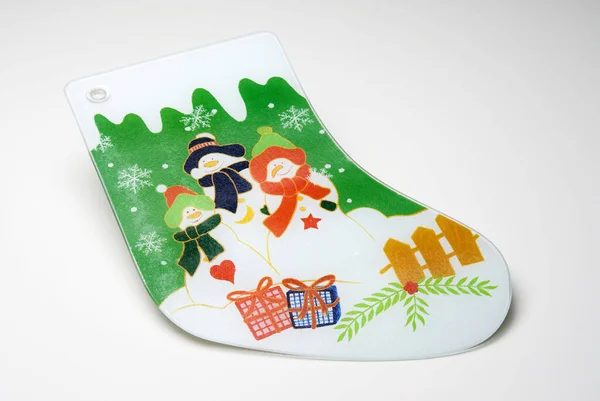 Glass cutting board in shape of christmas sock with three snowman illustration, isolated on white